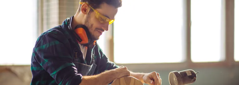 Energia+ stała cena. Stolarz pracujący w swoim warsztacie